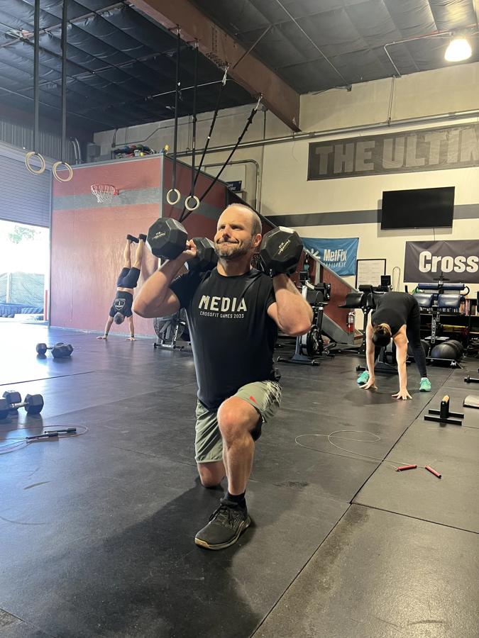 Athlete lunging with two dumbbells racked on shoulders